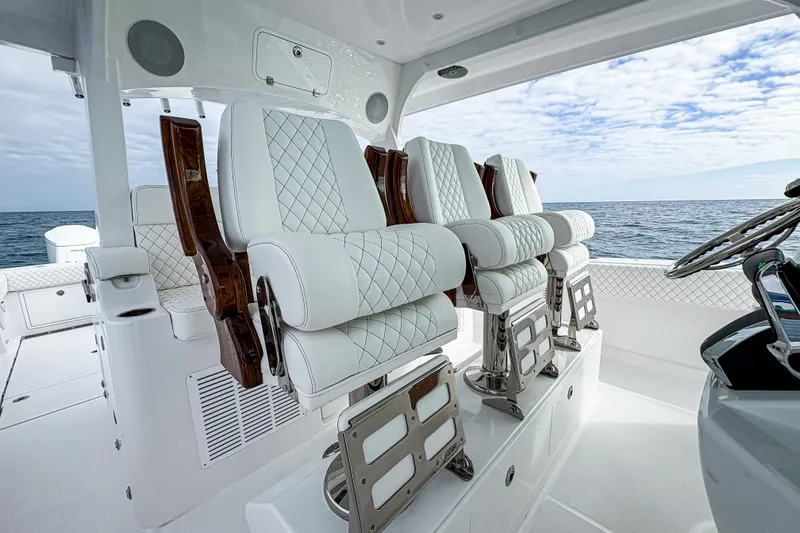 Slide: The Image of Luxurious seating on 2027 HCB 48 Campeon boat, featuring elegant white upholstery and ocean backdrop. - 37