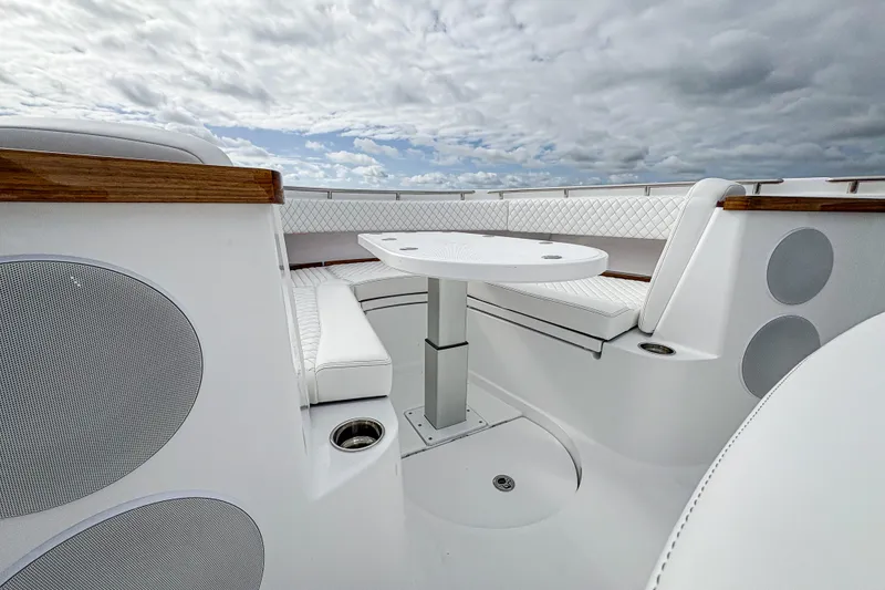Slide: The Image of Luxurious seating area on 2027 HCB 48 Campeon boat under cloudy sky. - 48