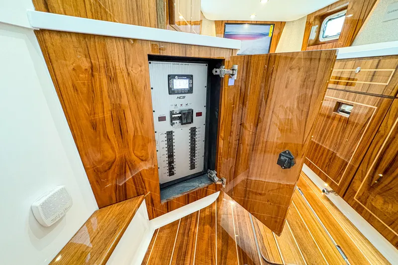 Slide: The Image of Electrical panel inside 2027 HCB 48 Campeon yacht, featuring luxurious wood finish. - 65