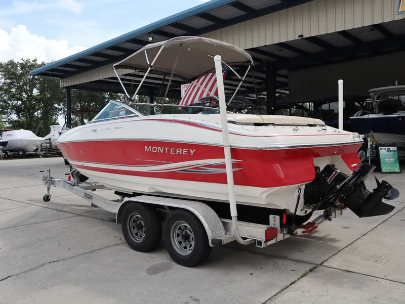 Slide: The Image of Red 2001 Monterey 200LS boat on trailer outdoors. - 17
