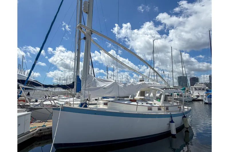 The Image of 1987 Nonsuch 30 Ultra sailboat docked at marina under blue sky. - 0