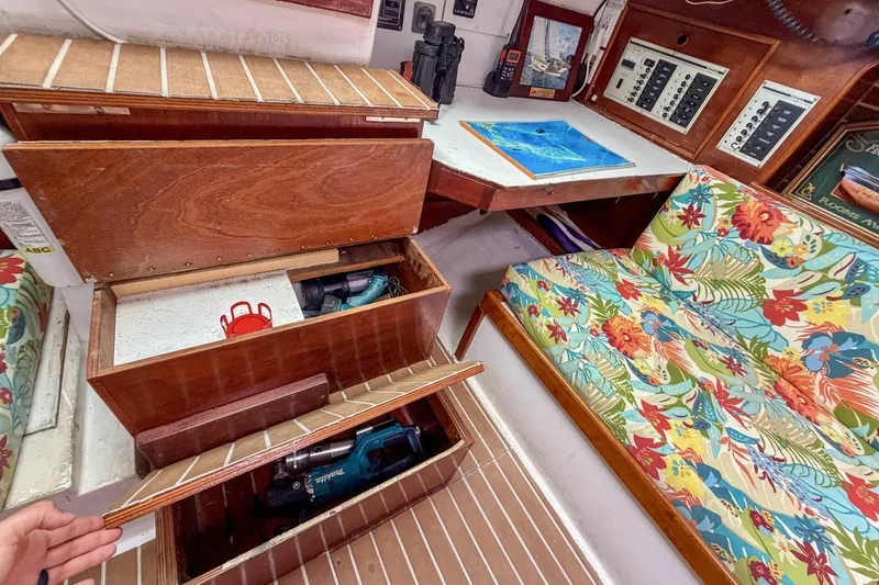 Slide: The Image of Interior of 1987 Nonsuch 30 Ultra sailboat with floral seating and wooden storage compartments. - 10