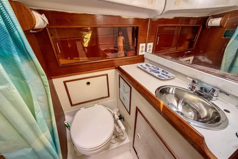 Slide: The Image of 1987 Nonsuch 30 Ultra yacht bathroom with wood accents, sink, and toilet. - 19
