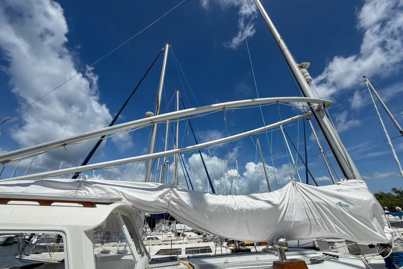 Slide: The Image of Sailboat Nonsuch 30 Ultra, 1987 model, docked under a vibrant blue sky. - 3