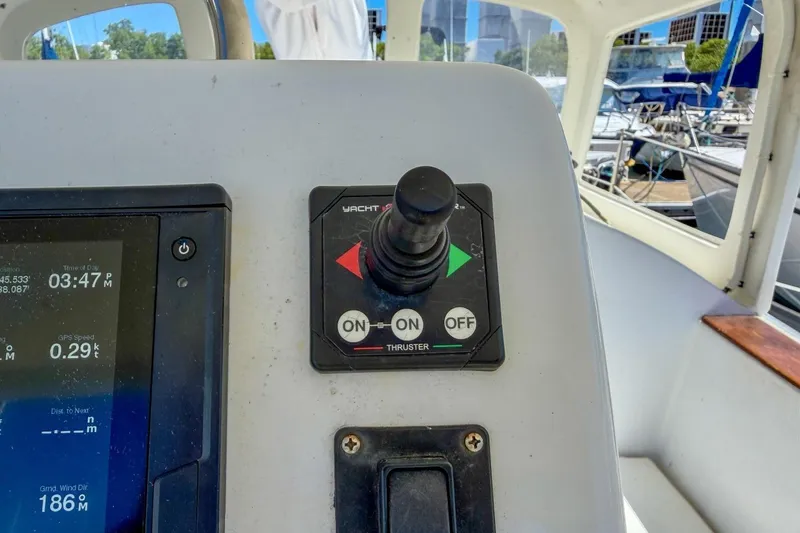 Slide: The Image of Cockpit controls of a 1987 Nonsuch 30 Ultra sailboat, featuring a thruster joystick. - 37
