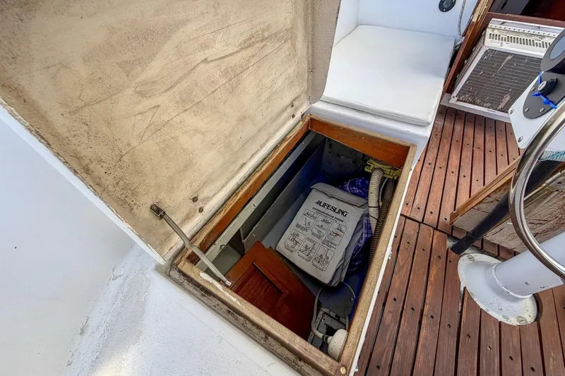 Slide: The Image of Open storage compartment on 1987 Nonsuch 30 Ultra sailboat deck, containing safety equipment. - 39
