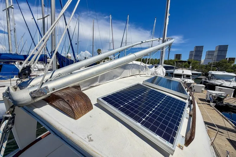 Slide: The Image of 1987 Nonsuch 30 Ultra sailboat with solar panels on deck, docked in marina. - 46