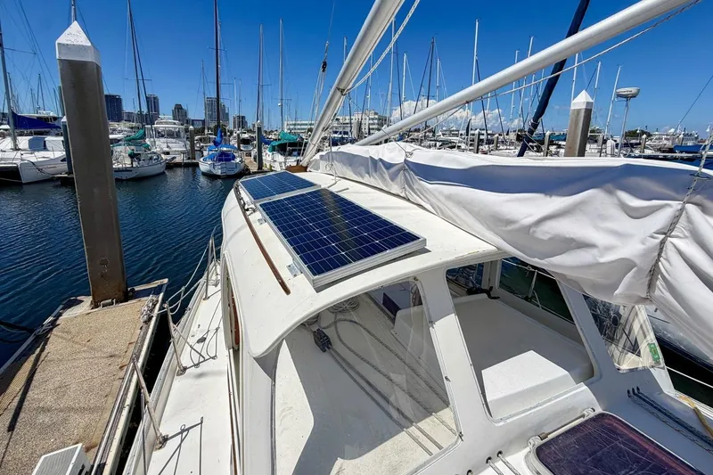 Slide: The Image of 1987 Nonsuch 30 Ultra sailboat with solar panels docked at a marina. - 47