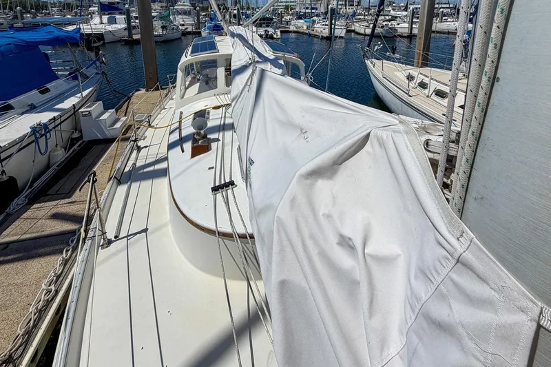 Slide: The Image of 1987 Nonsuch 30 Ultra sailboat docked at marina, covered sail, sunny day. - 48