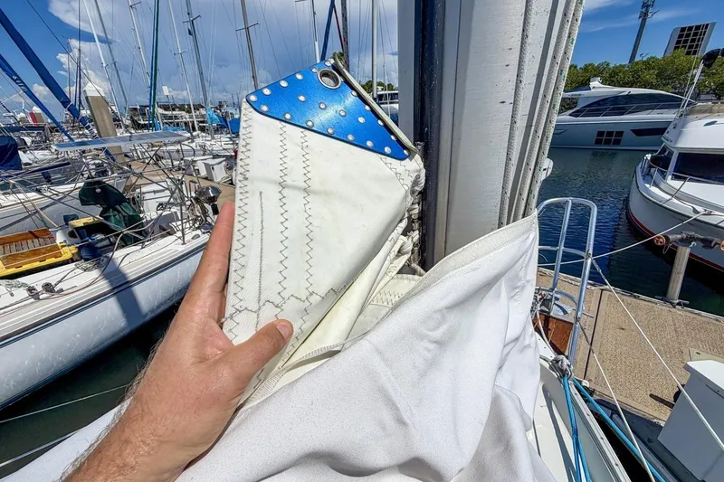 Slide: The Image of Hand holding sail on 1987 Nonsuch 30 Ultra yacht in marina. - 49