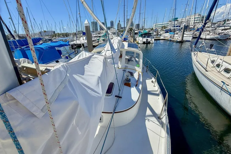 Slide: The Image of 1987 Nonsuch 30 Ultra sailboat docked in a marina, surrounded by other boats. - 50