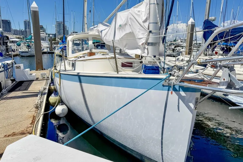 Slide: The Image of 1987 Nonsuch 30 Ultra sailboat docked at a marina on a sunny day. - 53