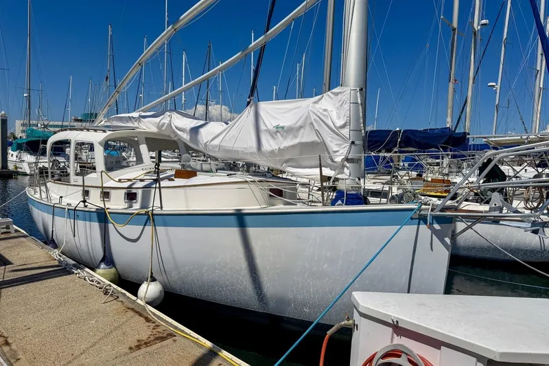 Slide: The Image of 1987 Nonsuch 30 Ultra sailboat docked at marina under clear blue sky. - 54