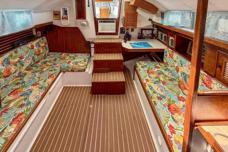 Slide: The Image of Interior of a 1987 Nonsuch 30 Ultra sailboat with floral upholstery and wooden accents. - 6