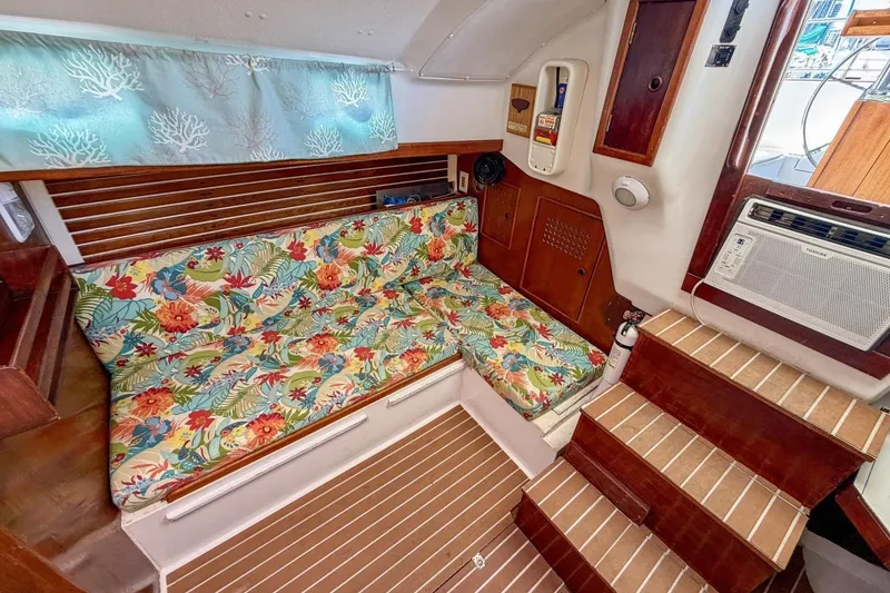 Slide: The Image of Cozy interior of 1987 Nonsuch 30 Ultra sailboat with floral cushions and wooden accents. - 7