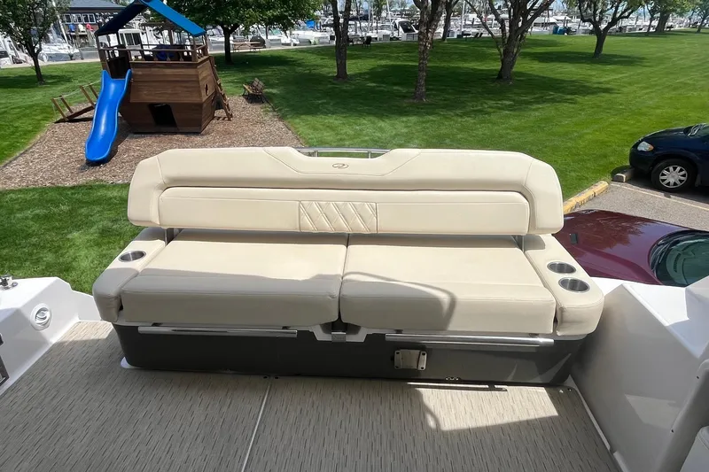 Slide: The Image of 2018 Regal 35 Sport Coupe boat with beige seating, playground, and marina in the background. - 15