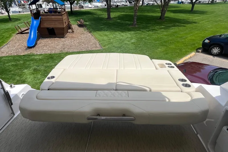 Slide: The Image of 2018 Regal 35 Sport Coupe sunpad with cup holders, playground in background. - 16