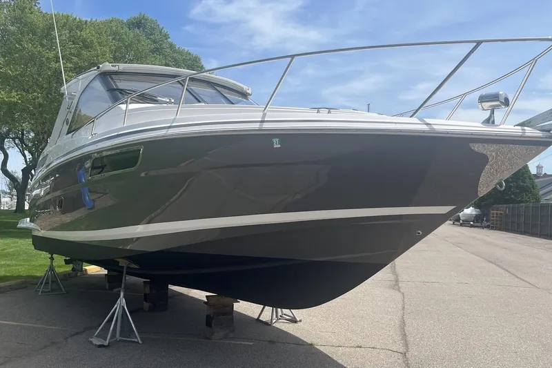 Slide: The Image of 2018 Regal 35 Sport Coupe boat on stands, parked outdoors. - 2