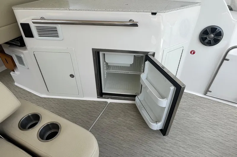 Slide: The Image of 2018 Regal 35 Sport Coupe interior with open mini fridge and cup holders. - 20