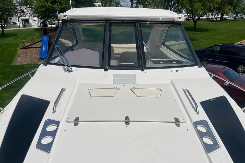 Slide: The Image of 2018 Regal 35 Sport Coupe boat with sleek design, docked near green park area. - 7