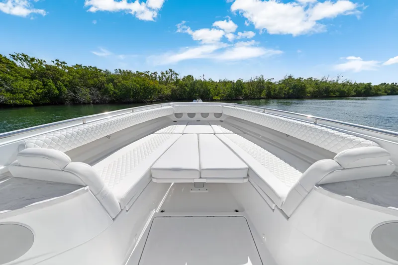 Slide: The Image of Luxurious 2027 HCB 53 Suenos boat interior with white seating, set against a serene water backdrop. - 14
