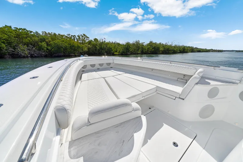 Slide: The Image of Luxurious 2027 HCB 53 Suenos boat interior with plush seating, cruising on a serene waterway. - 16