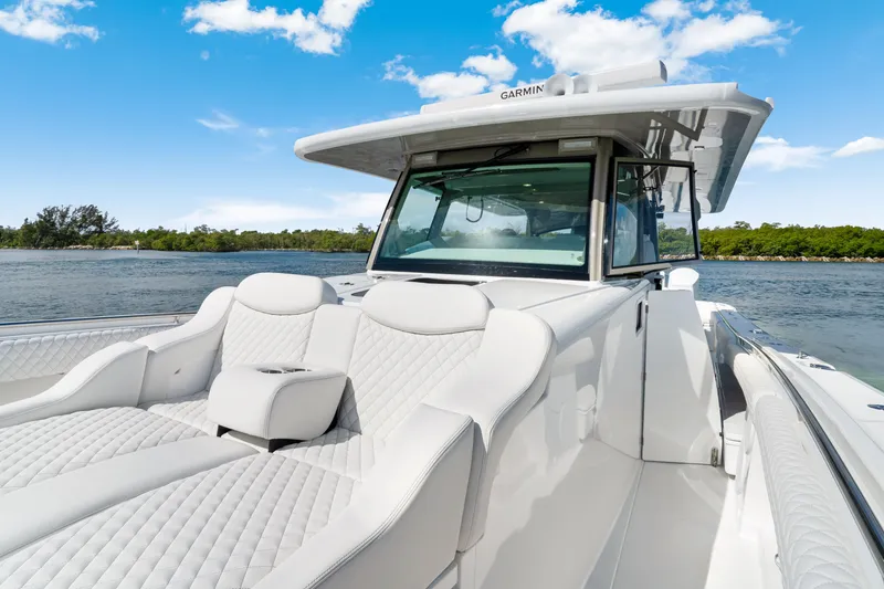 Slide: The Image of Luxury 2027 HCB 53 Suenos boat with plush seating on a sunny day. - 21