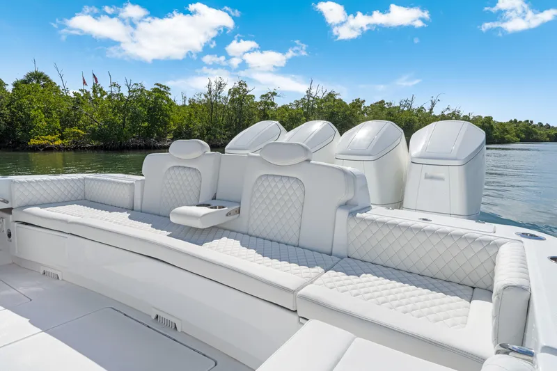 Slide: The Image of Luxurious seating on 2027 HCB 53 Suenos boat with quad engines, set against a scenic waterway. - 26