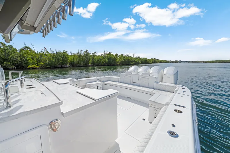 Slide: The Image of 2027 HCB 53 Suenos boat on calm water, featuring spacious deck and luxurious seating. - 27