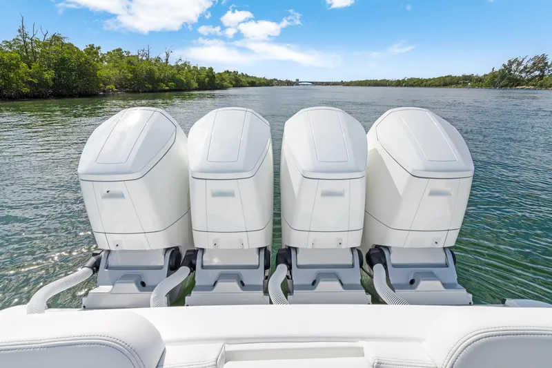 Slide: The Image of Four powerful outboard engines on a 2027 HCB 53 Suenos boat, cruising through scenic waters. - 28