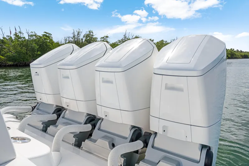Slide: The Image of Four powerful outboard engines on a 2027 HCB 53 Suenos boat, set against a scenic waterway. - 29