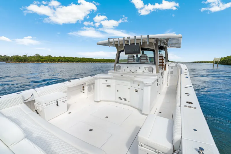 Slide: The Image of 2027 HCB 53 Suenos luxury boat on calm water, featuring spacious deck and modern design. - 31