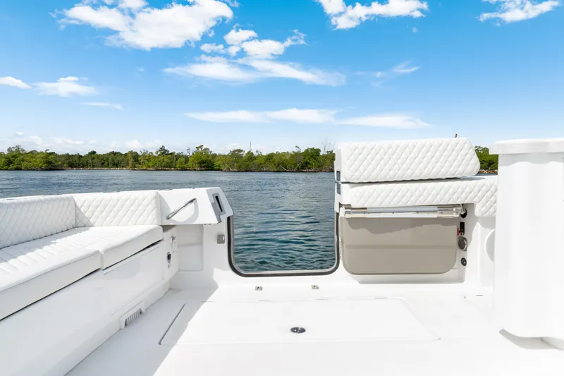 Slide: The Image of Luxury seating on 2027 HCB 53 Suenos boat, overlooking serene water and lush greenery. - 40