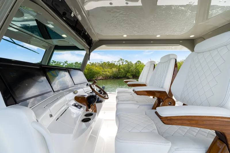 Slide: The Image of Interior of 2027 HCB 53 Suenos boat with luxurious white seating and advanced dashboard. - 48