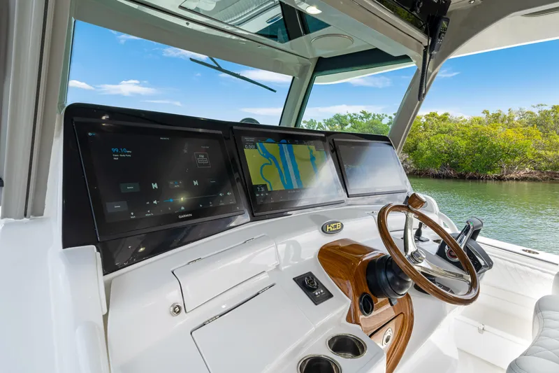 Slide: The Image of Helm of 2027 HCB 53 Suenos boat with advanced navigation displays and wooden steering wheel. - 49