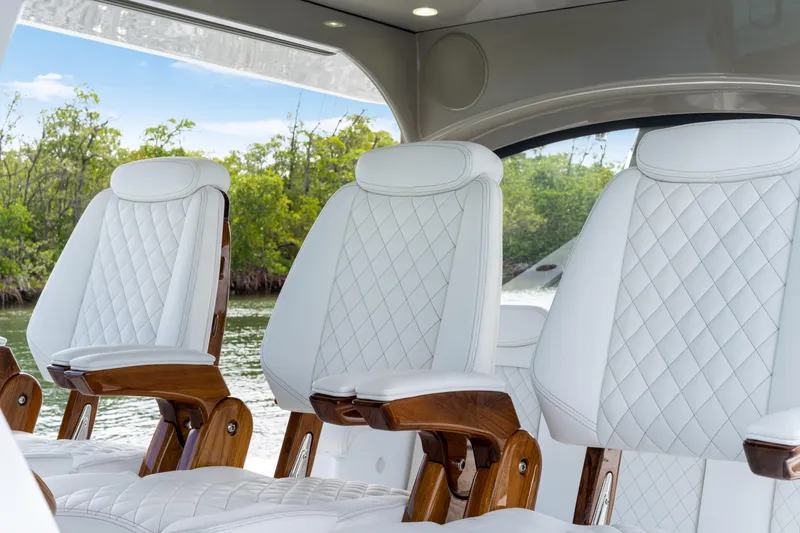 Slide: The Image of Luxurious white leather seats inside the 2027 HCB 53 Suenos boat, featuring elegant wood accents. - 57
