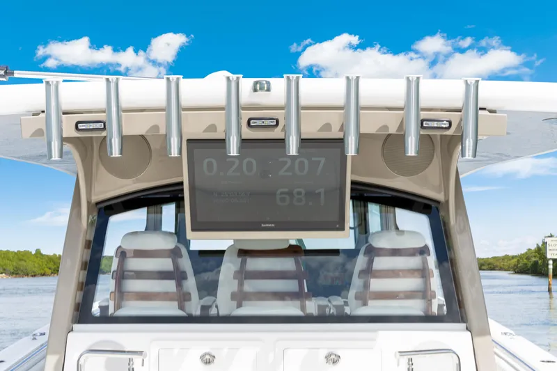 Slide: The Image of 2027 HCB 53 Suenos boat dashboard with rod holders and digital display under clear sky. - 59