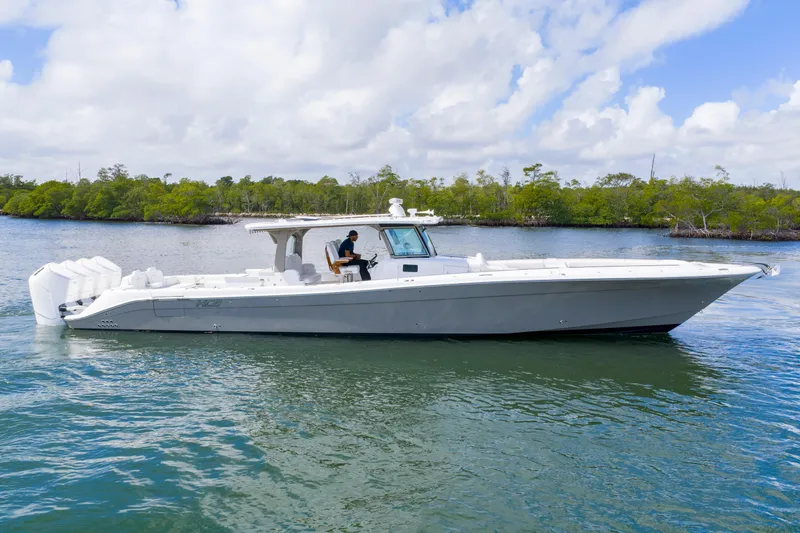 Slide: The Image of 2027 HCB 53 Suenos luxury boat cruising on calm water under a cloudy sky. - 7