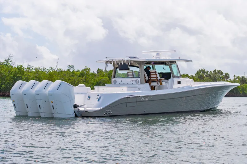 Slide: The Image of 2027 HCB 53 Suenos boat with four engines cruising on a calm waterway. - 8
