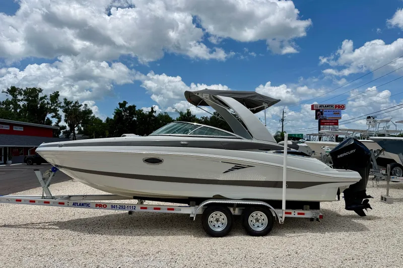 The Image of 2022 Crownline 260 XSS boat on trailer under cloudy sky at dealership. - 0