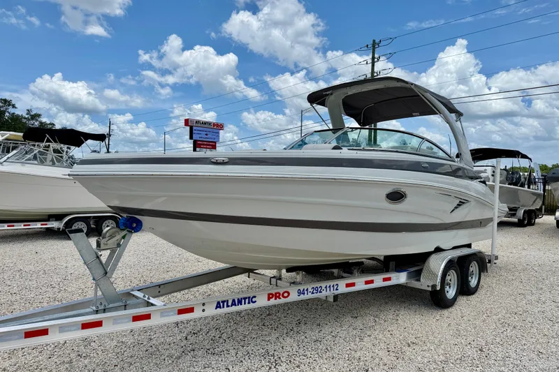 Slide: The Image of 2022 Crownline 260 XSS boat on trailer under blue sky. - 1