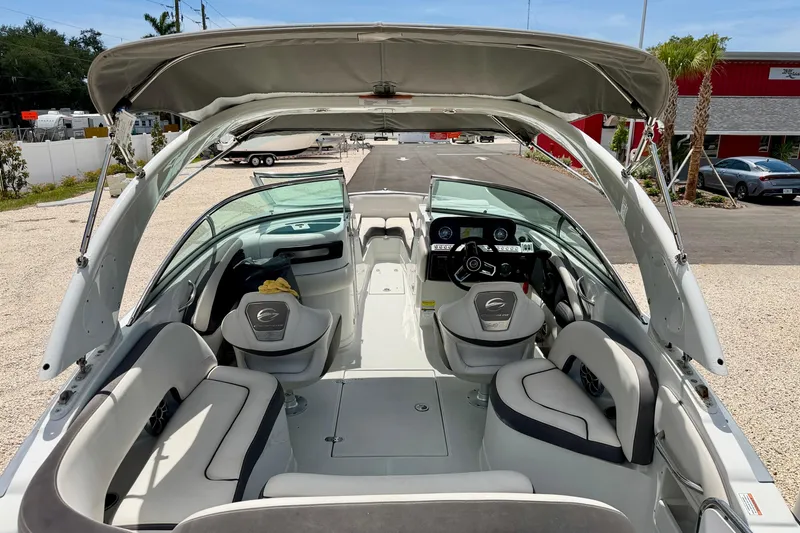 Slide: The Image of 2022 Crownline 260 XSS boat interior with seating, steering wheel, and canopy. - 13