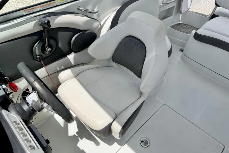 Slide: The Image of 2022 Crownline 260 XSS boat interior with steering wheel and cushioned seat. - 15