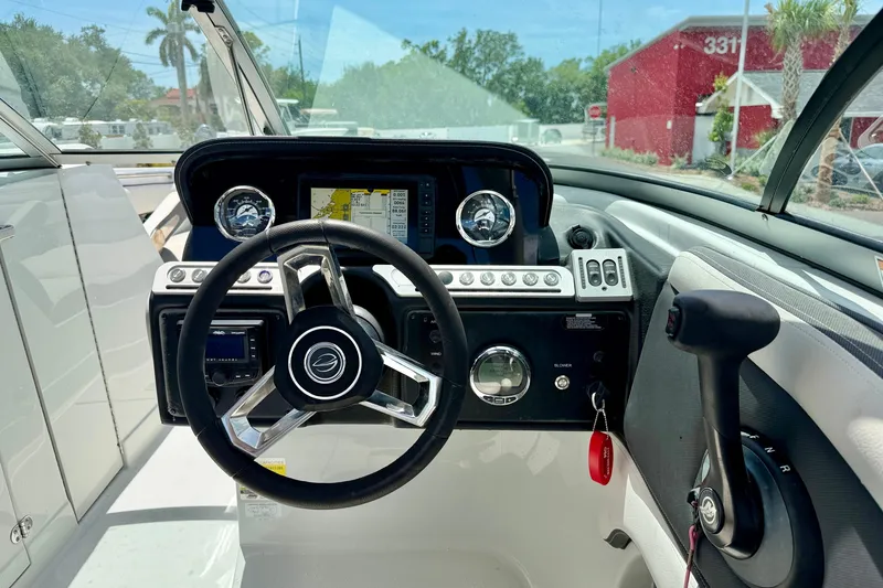 Slide: The Image of 2022 Crownline 260 XSS boat dashboard with steering wheel and navigation display. - 16