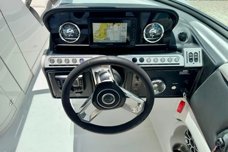 Slide: The Image of 2022 Crownline 260 XSS boat dashboard with steering wheel and Garmin navigation system. - 17