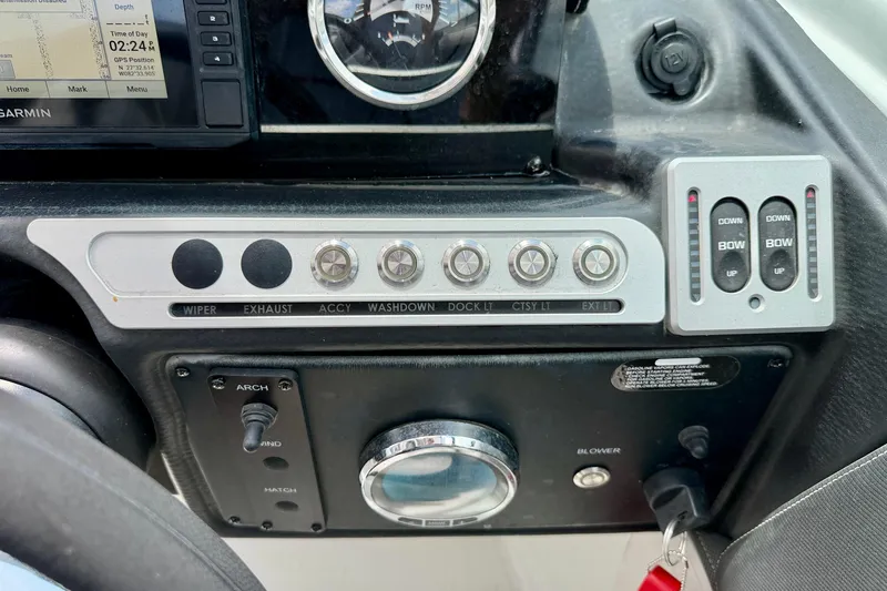 Slide: The Image of Control panel of a 2022 Crownline 260 XSS boat with various switches and gauges. - 19