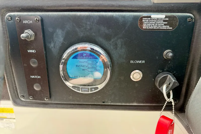 Slide: The Image of Control panel of a 2022 Crownline 260 XSS boat showing hours, battery, and blower switch. - 20