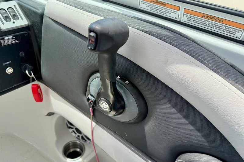 Slide: The Image of Throttle control panel of 2022 Crownline 260 XSS boat, featuring gear shift and warning labels. - 22