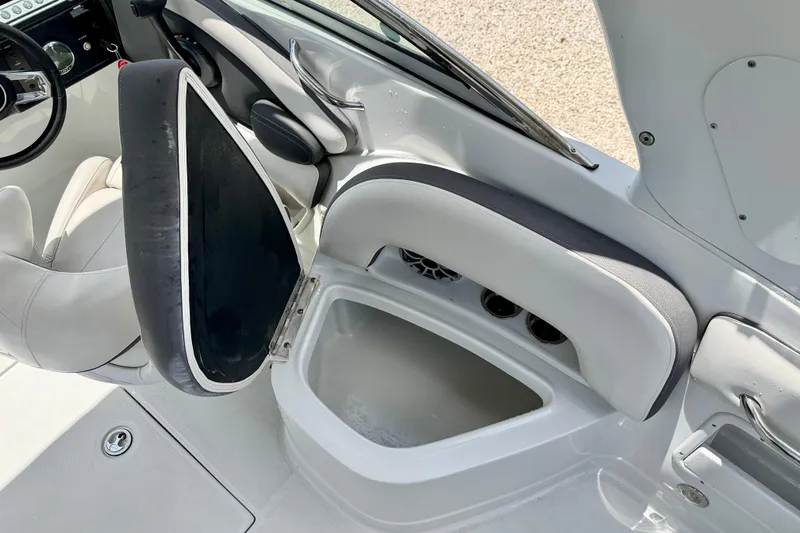 Slide: The Image of 2022 Crownline 260 XSS boat interior with open storage compartment and seating. - 27