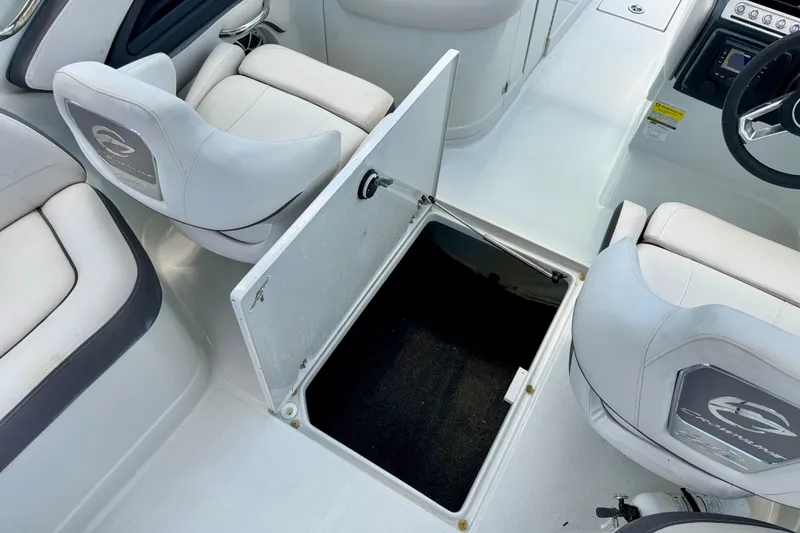 Slide: The Image of 2022 Crownline 260 XSS boat interior with open storage compartment and cushioned seating. - 28